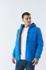 Campera de nylon azul con capucha, cierre frontal con cremallera, bolsillos laterales con cierre y logo de goma en el pecho.