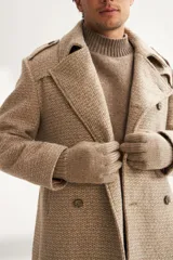 Saco marrón de lana con solapa, doble abotonadura, bolsillos, canesú y charreteras.