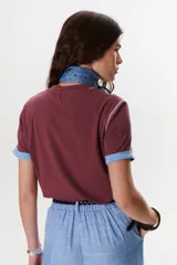 Remera blanca de manga corta con cuello redondo y detalle de costuras en contraste en cuello y mangas.