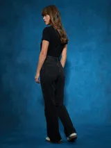 Jean de tiro alto, color negro, con corte recto y detalle de abertura con cierre en el bajo de la pierna.