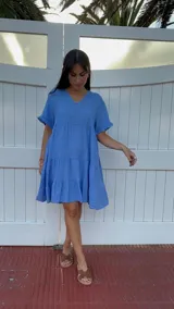 Vestido corto rojo con escote en V, mangas cortas con volados y corte escalonado.