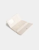 Billetera negra de cuerina con formato fichero y solapa bordada. Cuenta con sistema de apertura con broche a presión y compartimentos para tarjetas y billetes.