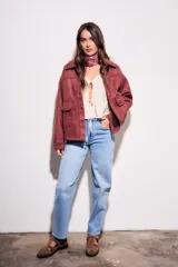 Sobrecamisa color borgoña de gamuza sintética con cuello camisero, cierre frontal con botones a tono, bolsillos de parche con solapa en el pecho y mangas largas con puños abotonados.