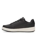 Zapatillas urbanas Under Armour negras con logo celeste en el lateral y suela color crema.
