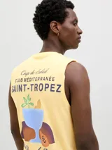 Musculosa sin mangas, color crema, con cuello redondo y calce relajado. Presenta un estampado gráfico en la espalda con texto en francés que hace referencia a Saint-Tropez y una ilustración de una bebida tropical.