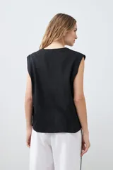 Chaleco negro con cuello en V y cierre frontal con botones. Confeccionado en lino.