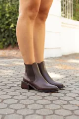 Botinetas estilo Chelsea de cuero vacuno con textura grabada tipo reptil. Presentan paneles laterales elásticos, punta almendrada y taco bajo cuadrado de madera.