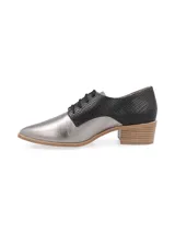 Zapato acordonado de cuero color plateado con puntera fina y detalle de cuero marrón en el talón.