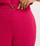 Pantalón zanahoria de cintura alta, confeccionado en tejido airflow color azul marino, con trabillas, cintura elástica y hebillas metalizadas.