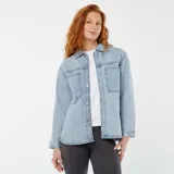 Sobrecamisa de denim celeste con cuello clásico, cierre frontal con botones a presión, mangas largas con puños abotonados, dos bolsillos de parche en el pecho y corte holgado.