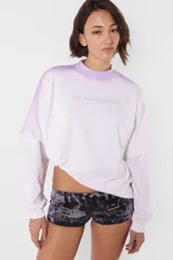 Remera lila con cuello alto y estampado frontal con la frase "Hot and Damaged". Diseño de mangas largas con corte a la altura del codo.