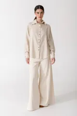 Camisa blanca de lino con botones de madera, corte recto y mangas largas.