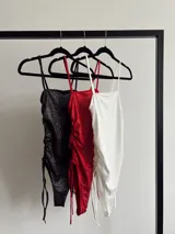 Body con brillo y frunce regulable a los lados, con broche en la parte inferior para mayor comodidad.