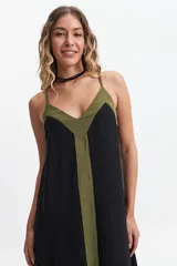 Vestido largo negro con breteles finos, escote en V y panel vertical color verde militar. Silueta amplia con tajos laterales.