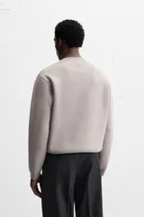 Sweater negro de punto con cuello redondo y mangas largas.