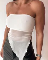 Top strapless blanco con corte irregular y tejido de red en la parte inferior.