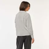 Camisa fluida de manga larga con estampado de rayas verticales blancas y negras.