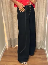 Pantalón ancho de denim con diseño patchwork en diferentes tonos de azul, con tiro alto, corte holgado y cierre frontal con botones.