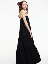Vestido largo strapless negro de fit amplio con volados en el bajo.