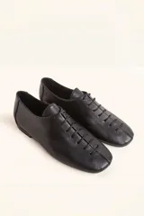 Zapatos chatos de cuero color bordó, con cordones finos y punta cuadrada.