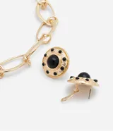 Conjunto de bijouterie dorado con collar de cadena gruesa con eslabones de clips y aros tipo botón con piedra negra.