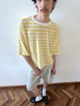 Remera de manga corta con estampado de rayas horizontales en color amarillo y blanco. Confeccionada en viscosa con cuello redondo de algodón, presenta un corte holgado a la altura de la cadera.