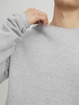 Sweater de punto gris claro jaspeado, de manga larga y cuello redondo.