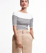 Blusa de punto con textura acanalada, escote barco y mangas 3/4. Diseño a rayas horizontales blancas y negras.