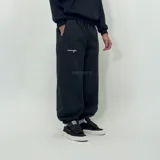 Pantalón de jogging gris, corte oversize, confeccionado en felpa suave con elástico en la cintura y puños.