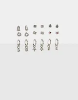 Set de nueve pares de aros pasantes y argollas de metal plateado con strass y esmaltado.