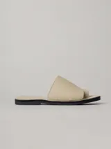 Sandalias planas color beige de cuero, con tira ancha sobre el empeine y tira entre los dedos.