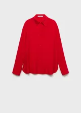 Camisa celeste de tejido fluido con cuello camisero, cierre frontal con botones y mangas largas con puños abotonados.