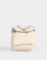 Mochila de cuerina color crema, con diseño acolchado y pespuntes diagonales. Tiene solapa con broche decorativo y botón para cerrar, correa de ajuste metálica, manija superior y correas regulables.