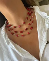 Collar de tres hilos con cuentas de piedra coral y detalles plateados.
