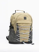 Mochila gris claro y gris oscuro con cordones elásticos cruzados en el frente y logo de la marca en la parte superior.