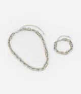 Conjunto de collar y pulsera de metal plateado y dorado con eslabones gruesos.