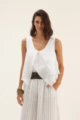 Musculosa blanca de lino con volados en el frente.