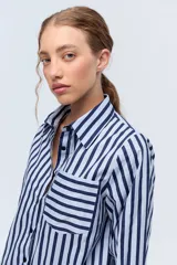Camisa de algodón con diseño a rayas en tonos azules, de corte clásico y bolsillo frontal.