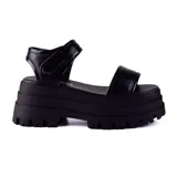 Sandalias negras con plataforma alta y suela track. Tiras anchas sobre el empeine y ajuste con velcro en el tobillo.