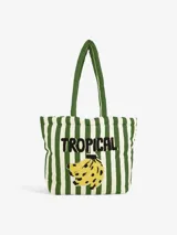 Bolso tipo tote bag de algodón con rayas verticales verdes y blancas. Presenta bordado con la palabra "Tropical" y un racimo de bananas. Tiene asas de hombro acolchadas en color verde.