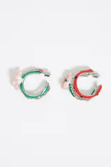 Aros de argolla con forma de media luna, decorados con strass y una flor rosa con centro verde.