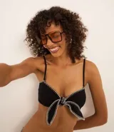 Top de bikini bandeau negro con tirantes extraíbles, lazo delantero y pespunte contrastante blanco.