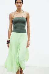 Falda midi plisada color verde menta, de tiro alto, con forro interior y cierre lateral con cremallera oculta.