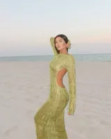 Vestido largo de tejido calado color verde, con mangas largas y espalda descubierta.