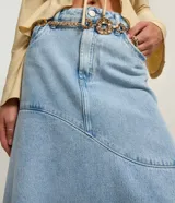 Pollera midi de jeans celeste claro con diseño de recortes y bajo irregular deshilachado. Presenta cintura con trabillas y cierre frontal.
