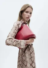 Vestido midi con estampado de serpiente, cuello camisero, cierre frontal con botones, cinturón decorativo y mangas largas con puños abotonados.