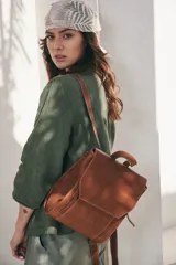 Mochila de cuero color marrón con cierre de solapa y hebilla, tamaño mediano.