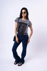 Remera gris con efecto acid wash y estampa frontal con tres figuras femeninas.