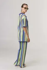 Pantalón de tejido crochet a rayas verticales en tonos rosa, naranja y violeta, de corte palazzo.