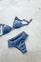 Conjunto de bikini azul con estampado difuminado. Incluye corpiño de triángulo fijo con breteles regulables y almohadillas desmontables, y bombacha vedetina de tiro alto.